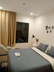 a bedroom with a bed and a large window at FThomestay at Vinhome Grand Park HCM in Gò Công