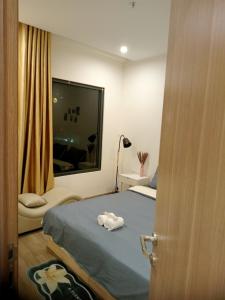a bedroom with a bed and a window with a towel at FThomestay at Vinhome Grand Park HCM in Gò Công