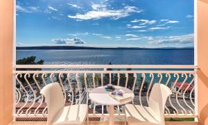 balcón con mesa, sillas y vistas al agua en Mediteran Hotel by Aminess en Crikvenica