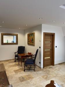 a living room with a table and chairs and a door at Brezno Central Apartments in Brezno