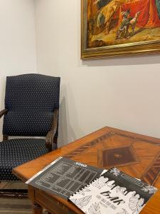 a table and a chair with a table and a painting at Brezno Central Apartments in Brezno