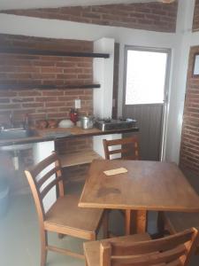 eine Küche mit einem Holztisch und Stühlen in der Unterkunft Cabañas La Mision in Chignahuapan