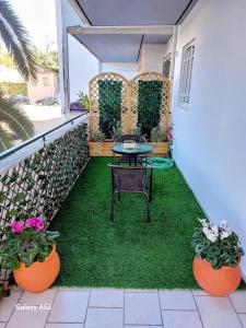 a patio with a table and two potted plants at Jimmy’s Beautiful Sparta Home in Sparti