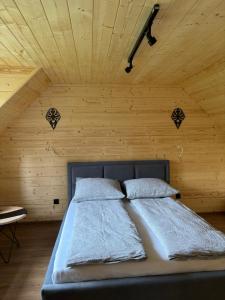 a bed in a room with a wooden ceiling at Domek nad Dunajcem in Krościenko