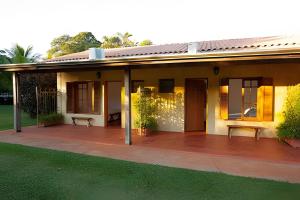una casa con un porche con césped verde en Fazenda Santa Teresa de 1 a 30 pessoas en Bocaina
