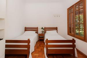 dos camas sentadas una al lado de la otra en una habitación en Fazenda Santa Teresa de 1 a 30 pessoas en Bocaina