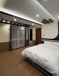 a bedroom with a large white bed in it at Pine Tree Resort in Bhaktapur