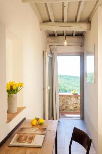 a dining room with a wooden table and a window at Casale Sterpeti in Magliano in Toscana
