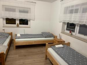 a room with two beds and two windows at Domek nad Dunajcem in Krościenko