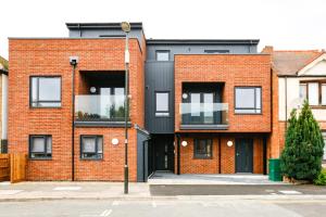 una casa de ladrillo rojo con una fachada negra en Hybrid Resi - Mitcham close to Tooting and Wimbledon, en Mitcham