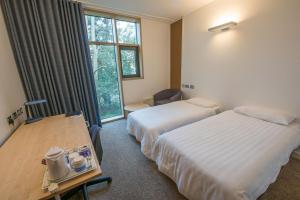 a hotel room with two beds and a desk and a window at Stephen Hawking Building Gonville and Caius College in Cambridge