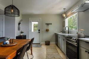 uma cozinha com uma mesa de madeira e uma sala de jantar em Perch Eagle House: Creek access + mountain views em Boiceville