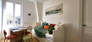 ein Zimmer mit einer Couch mit bunten Kissen darauf in der Unterkunft Primavera : Beau 2-pièces proche Paris, RER B 450m in Gentilly