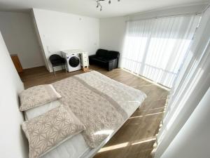 um pequeno quarto com uma cama e um sofá em Modern One Bedroom + Bathroom Apartment, 10 min from Basel City em Grenzach-Wyhlen