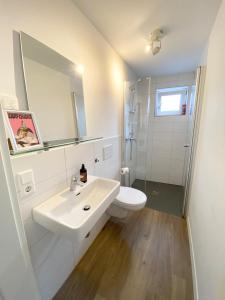 uma casa de banho branca com um lavatório e um chuveiro em Modern One Bedroom + Bathroom Apartment, 10 min from Basel City em Grenzach-Wyhlen