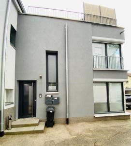 une maison grise avec deux portes et une fenêtre dans l'établissement Modern One Bedroom + Bathroom Apartment, 10 min from Basel City, à Grenzach-Wyhlen