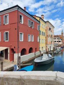 a boat is docked in a canal with buildings at Canal Vena Suite House by ApartSuite in Chioggia
