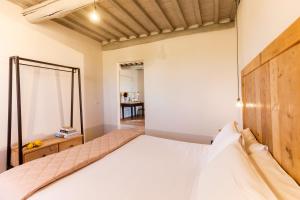 a bedroom with a bed with a wooden headboard at Casale Sterpeti in Magliano in Toscana