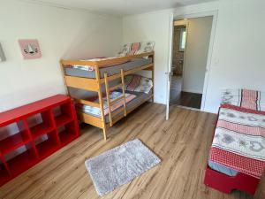 Zimmer mit 2 Etagenbetten und Holzboden in der Unterkunft See und Berge Family in Faulensee