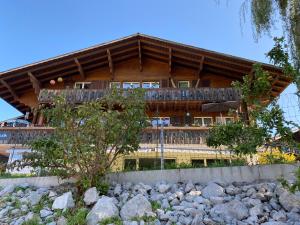 ein großes Holzgebäude mit Balkon oben in der Unterkunft See und Berge Family in Faulensee