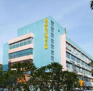 un bâtiment bleu avec un panneau jaune dans l'établissement Platinum Times Aparthotel, à Shenzhen