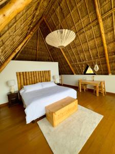 a bedroom with a bed in a straw roof at Hotel Bambu in Santiago Atitlán