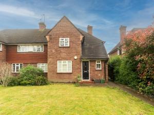 a large brick house with a grass yard at Lovely cosy gem with free parking Pass the Keys in Surbiton