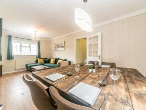 a living room with a wooden table with wine glasses at Lovely cosy gem with free parking Pass the Keys in Surbiton