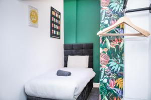 1 dormitorio con cama y pared verde en Duke's Den - Liverpool City en Liverpool