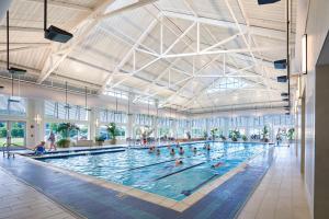 a large indoor swimming pool with people in it at Bayside Resort --- 38047 Boxwood Terrace #101 in Selbyville