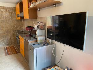 a kitchen with a large flat screen tv on the wall at Stella Marina in Stari Grad