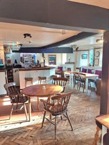 a dining room with tables and chairs and a kitchen at The White Hart in Oxford