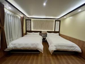 two beds in a room with white sheets at Pine Tree Resort in Bhaktapur