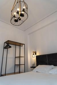 a bedroom with a bed and a chandelier at Ophelia - New Modern Apartment with Spectacular Olympus View in Litochoro
