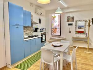 シラクーサにあるカーサ セレステのキッチン(青いキャビネット、テーブル、椅子付)