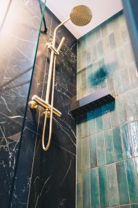 a bathroom with a shower with a black marble wall at LVM Stays in The Hague