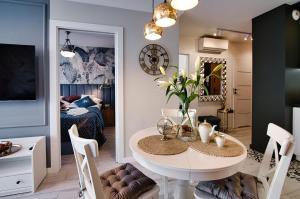 a dining room with a table and a bedroom at Apartament Bulwary317 in Oświęcim