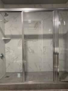 een douche met een glazen deur in de badkamer bij L.A. Sky Boutique Hotel in Los Angeles