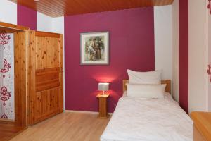 a bedroom with a bed and a purple wall at Apartment Babenhausen in Babenhausen