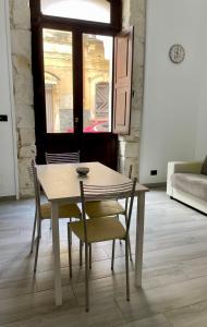 einen Tisch und Stühle in einem Zimmer mit Fenster in der Unterkunft Luxury home in Syrakus