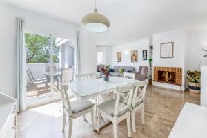 una sala da pranzo e un soggiorno con tavolo e sedie bianchi di Apartamento Puerto Banús IV a Marbella