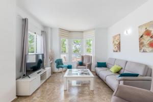 uma sala de estar com um sofá e uma televisão em Apartamento Puerto Banús IV em Marbella