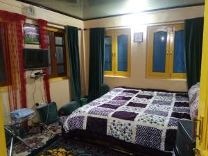 a bedroom with a bed with a quilt on it at Homestay Hari Parbat in Srinagar