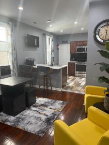 a kitchen and living room with a table and yellow chairs at Feel at home when you’re away in Philadelphia