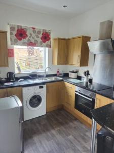 a kitchen with a washing machine and a washer at 3 Bedroom house, close to woodland, chesterfield and peak District in Brimington