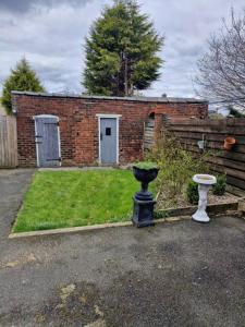 a brick house with a yard with a vase at 3 Bedroom house, close to woodland, chesterfield and peak District in Brimington