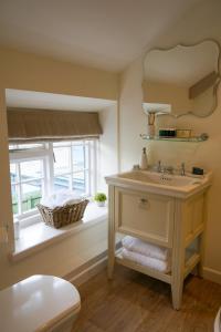 a bathroom with a sink and a window at The Bluebell Country Inn, Crickhowell in Crickhowell