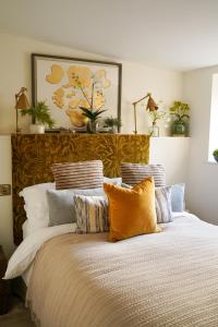 Un dormitorio con una cama grande con muchas almohadas en The Bluebell Country Inn, Crickhowell en Crickhowell