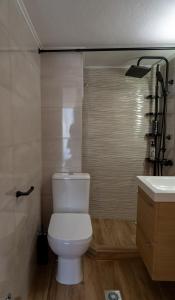 a bathroom with a white toilet and a sink at Ophelia - New Modern Apartment with Spectacular Olympus View in Litochoro