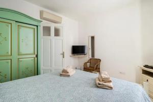 a bedroom with a bed with towels on it at B&B Affittacamere Via del Centro in La Maddalena